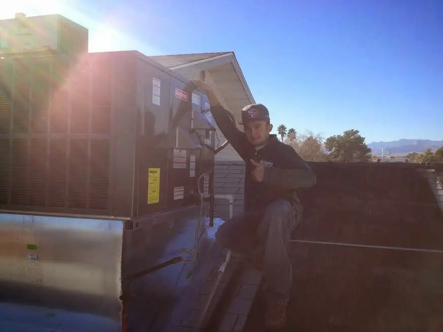 HVAC technician performing Heat Pump Repair on a rooftop unit in Pittsford